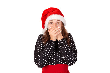Close-up portrait of a young woman scared and afraid with wide opened eyes. emotional girl in santa claus christmas hat isolated on white background. holiday concept