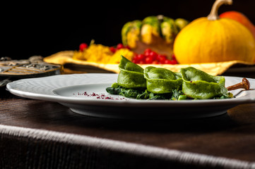 Green Ravioli with quail egg on a black background. A Halloween Feast.