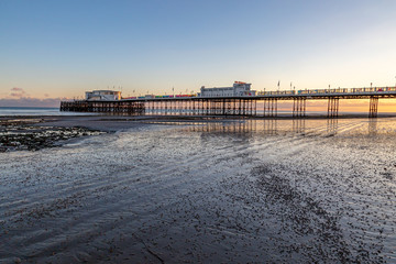 Worthing Pier in Sussex, at low tide during sunset