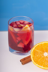 Бокал с глинтвейном и апельсином на синем фоне 
