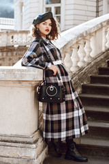 Outdoor full body fashion portrait of young beautiful fashionable girl wearing autumn long checked...