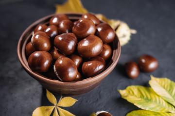 Fresh chestnuts on background autumn leaves