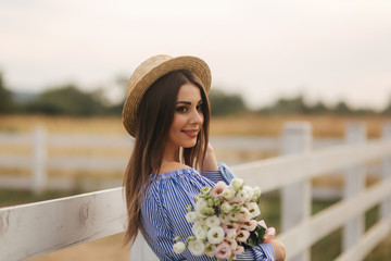 Charming pregnant woman hold a bouquet of flowers. Happy woman smile. Future mother in nature
