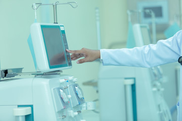 Fototapeta na wymiar Medical treatment Doctor touch button turn on Dialysis machine