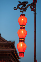 Fototapeta na wymiar Illuminated red chinese lanterns on the fortified wall at night in Xi'an, China