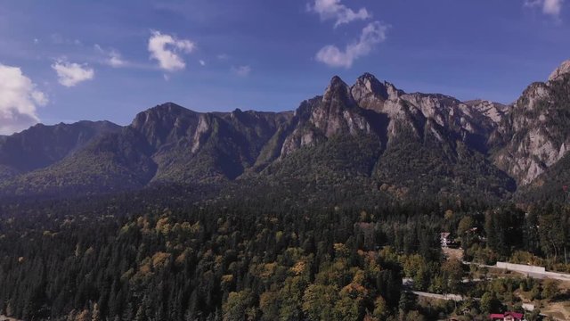 Aerial view of Busteni ski resort in Prahova valley and Bucegi mountain part of Carpathian mountains. Brasov region in Transilvania, Romania. Sunny autumn landscape