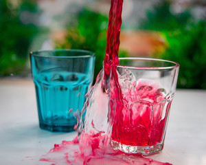 The drink is beautifully poured past the glasses. Напиток красиво разливающийся мимо бокалов.