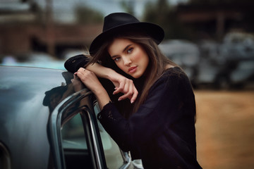 Young female brunette model with retro car