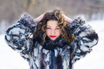 girl with curtains in winter in gray coat