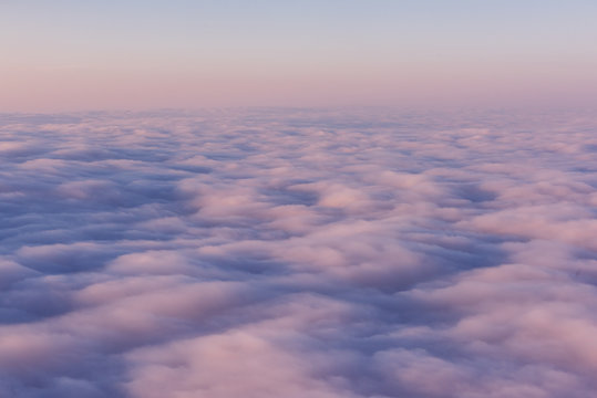 A field of pink clouds at sunset. View from above. Sky feather beds.
