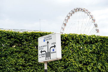 Paris street sign with Trocadero, Concorde directions and Grande Roue de Paris ferris wheel