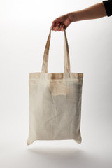 cropped image of woman holding cotton bag with food delivery on white