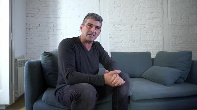 Thoughtful Depressed And Middle Aged Old Man Sitting On His Couch At Home Looking Out The Window In Depression Mental Health Concept.