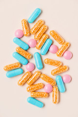 top view of various colorful pills on beige surface