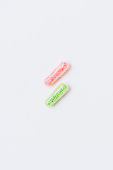 top view of pink and green medical capsules on white