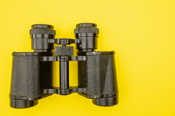 Binoculars on a yellow background.