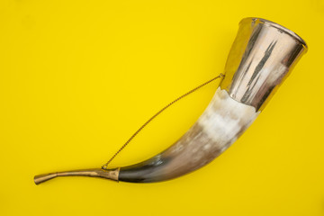 Horn for drinking wine on a yellow background.