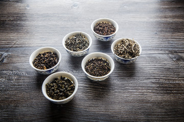 assorted tea leaves in six white small round vessels