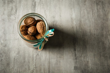 top view on standard open glass jar filled with whole walnuts