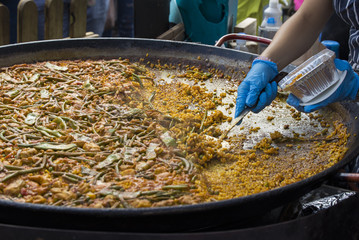 Street food: cooking and serving paella, traditional spanish rice dish