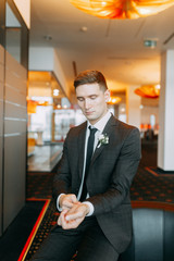 Stylish minimalism in the image of the groom. Black color and European wedding. The preparations of the groom, hotel