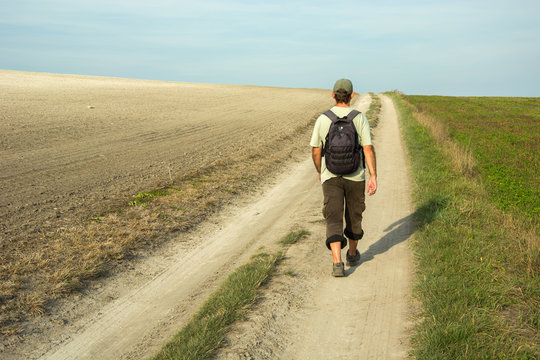 Man wandering a dirt road