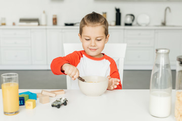 portrait of little boy having breakfast in kitchen at home