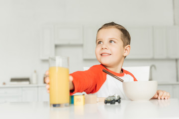portrait of little boy having breakfast in kitchen at home