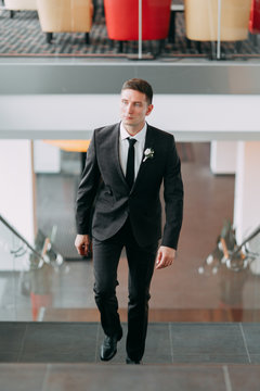 Stylish minimalism in the image of the groom. Black color and European wedding. The preparations of the groom, hotel