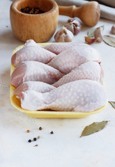 fresh raw chicken pieces on a light background in a tray