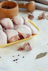 fresh raw chicken pieces on a light background in a tray