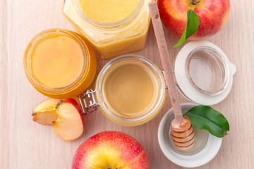 Jewish holiday Rosh Hashanah background with honey and apples on wooden table.