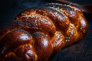 Fresh homemade bun with poppy seeds, with ingridients on dark rustik background. Copy space for text, brand or logo. Concept photo of low key bakery. Close up and top view