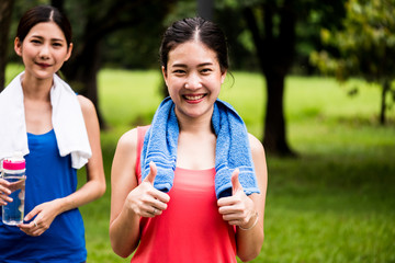 Fototapeta premium Portrait of young girl jogging in a park with her friend