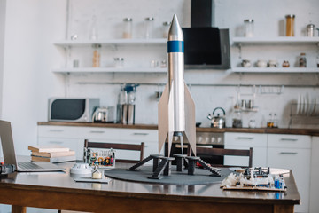 rocket model and tools for engineering on table in kitchen