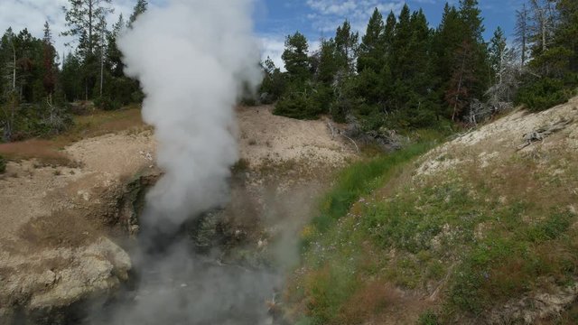 Steady shot of the Dragon’s Mouth Spring releasing billows of hot steam at Yellowstone National Park in Wyoming.