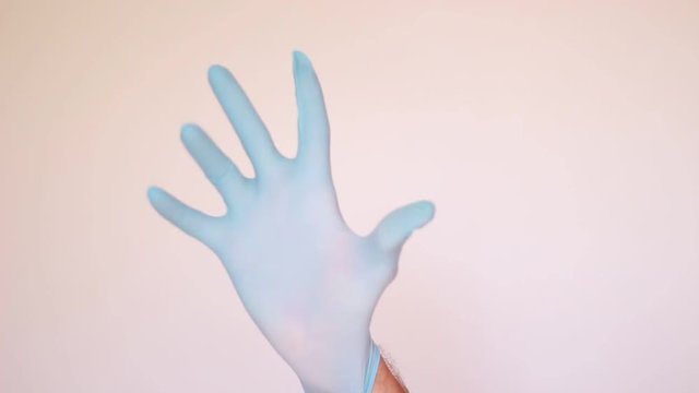 Doctor putting on blue glove
