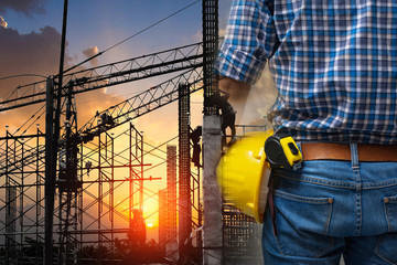 Back view of Double exposure  Engineer construction architect holding roll safety helmet outdoor of construction site in evening.copy space.