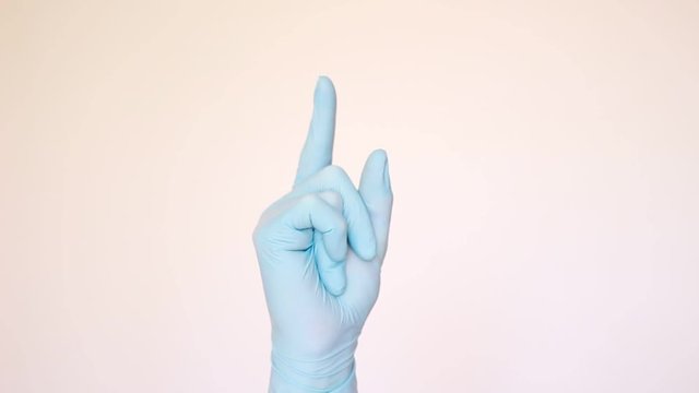 Doctor in blue gloves rising his forefinger