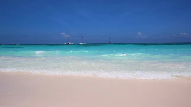 A wave rolling on the white sand of a Caribbean island.