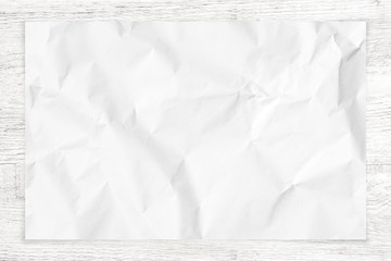 Crumpled paper texture on wood background.