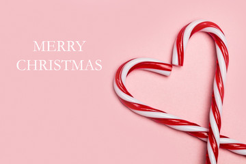Cartel fondo Merry Christmas con bastones de caramelo sobre fondo rosa aislado. Vista superior....