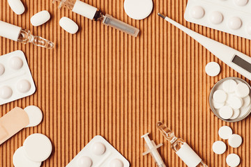 Fototapeta na wymiar top view of various medical instruments and drugs on cardboard background