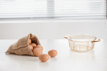 Fototapeta na wymiar Eggs in a sack bag on wooden background.