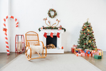 decorated room with rocking chair, christmas tree and presents for winter holidays celebration