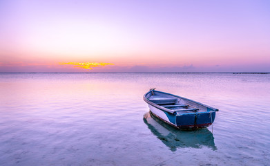 Mauritius Boat in the sea with pink and purple colors during Sunset in beautiful Mauritius paradise...