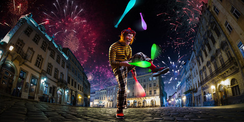 Night street circus performance whit clown, juggler. Festival city background. fireworks and Celebration atmosphere. - obrazy, fototapety, plakaty