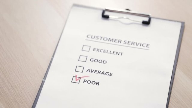 Man putting a check sign at "poor" square at a customer satisfaction survey