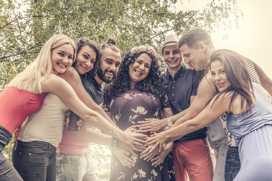 pregnant women enjoys stroking hands of her friends on her baby belly. real friendship concept. we are one big family.