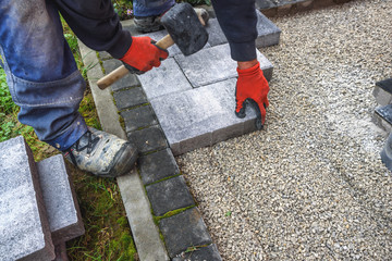 paving blocks. hand with rubber hammer  install paving block
